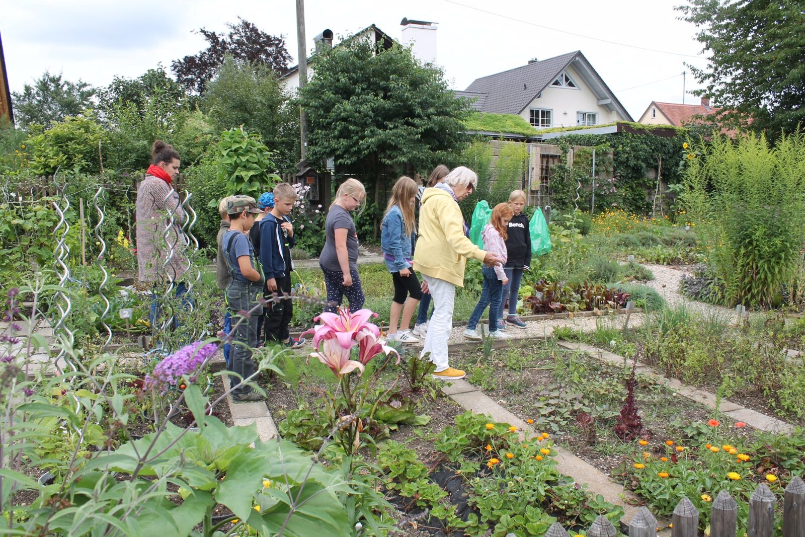Christine Baier zeigt den am Ferienprogramm teilnehmenden Kindern die Beete des Aichacher Gartenbauvereins und erklärt die Pflanzen.