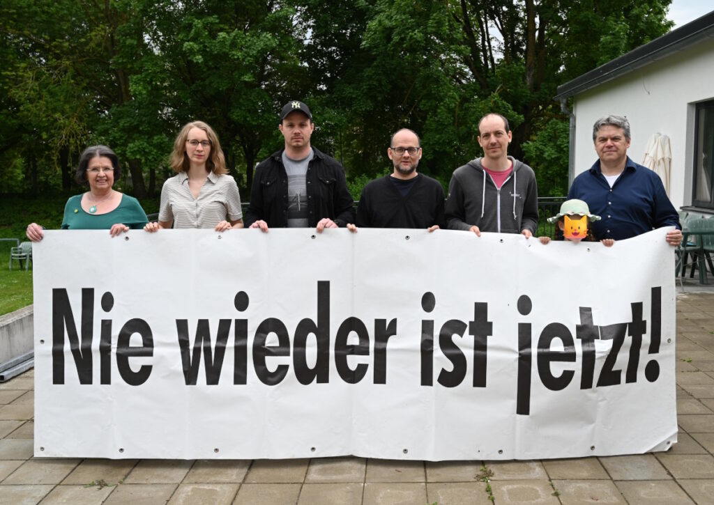 Grüne des Kreisverbands Aichach-Friedberg gemeinsam mit Eva Lettenbauer hinter einem Transparent mit der Aufschrift "Nie wieder ist jetzt"